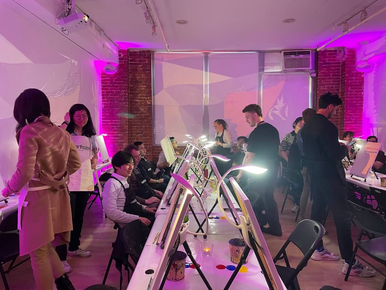 Guests painting and mingling at Unarthodox immersive art experience